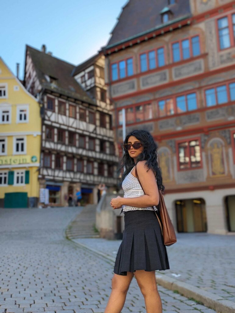 Ein junger Frau steht vor dem Tübinger Rathhaus in Tübingen und trägt einen regional gefertigten Rucksack von Hepco
