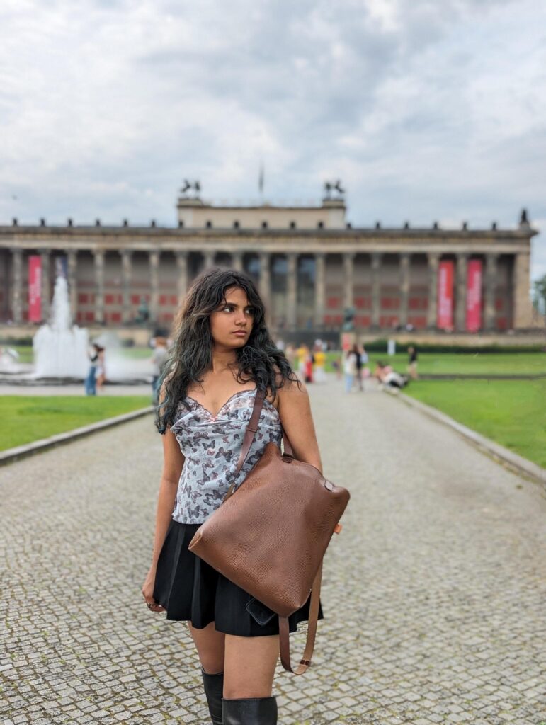 Eine junge Frau steht in Berlin mit einem Lederrucksack der Marke Hepco vor dem alten Museum. Berlin.
